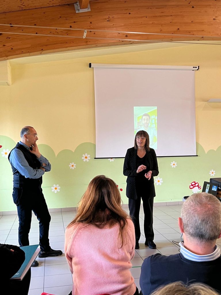 Foto di un momento di spiegazione con due docenti in piedi vicino al videoproiettore